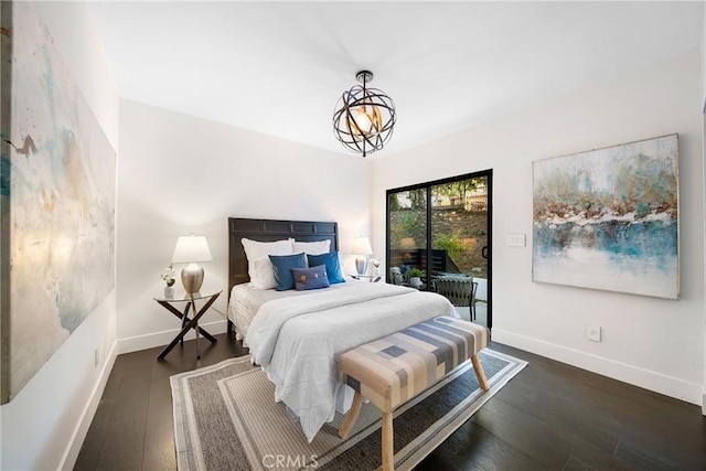 bedroom with access to outside, an inviting chandelier, baseboards, and hardwood / wood-style flooring