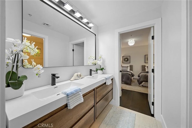 full bath with double vanity, connected bathroom, visible vents, and a sink