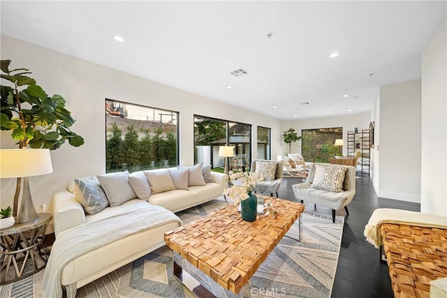 living area with a wealth of natural light, visible vents, recessed lighting, and wood finished floors