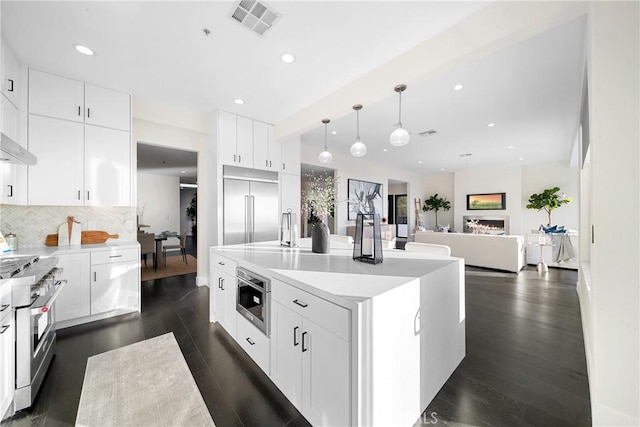 kitchen with tasteful backsplash, visible vents, high end appliances, dark wood-style floors, and recessed lighting