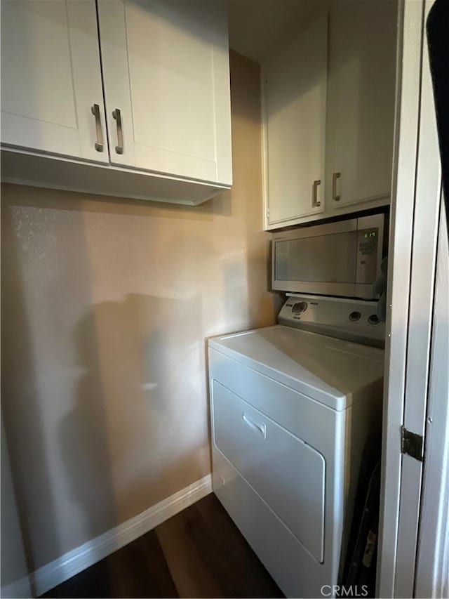 washroom with dark hardwood / wood-style flooring, cabinets, and washer / clothes dryer