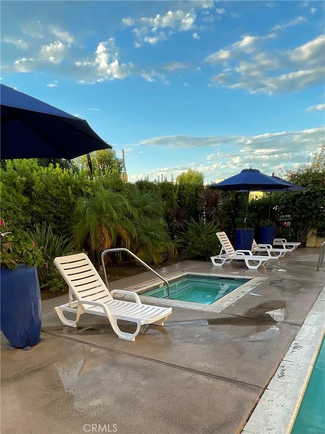 view of pool featuring an in ground hot tub and a patio