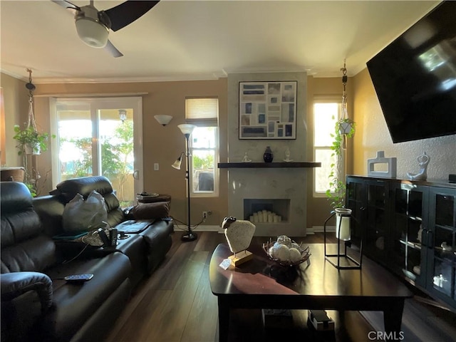 living room featuring ceiling fan, a healthy amount of sunlight, wood-type flooring, and ornamental molding