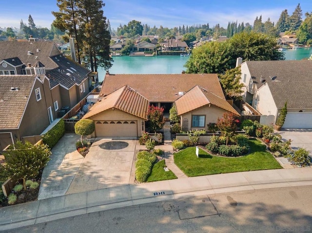 view of front facade with a water view, a garage, and a front lawn