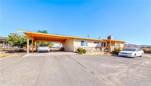 11507 Savage Ln, Apple Valley, CA 92308 - single story home featuring stucco siding, a chimney, a carport, and a mountain view