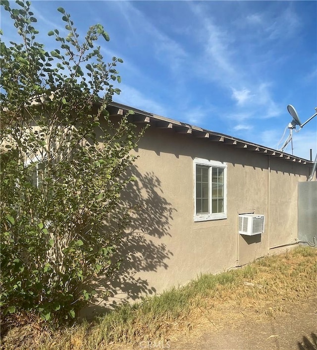 view of side of property with an AC wall unit