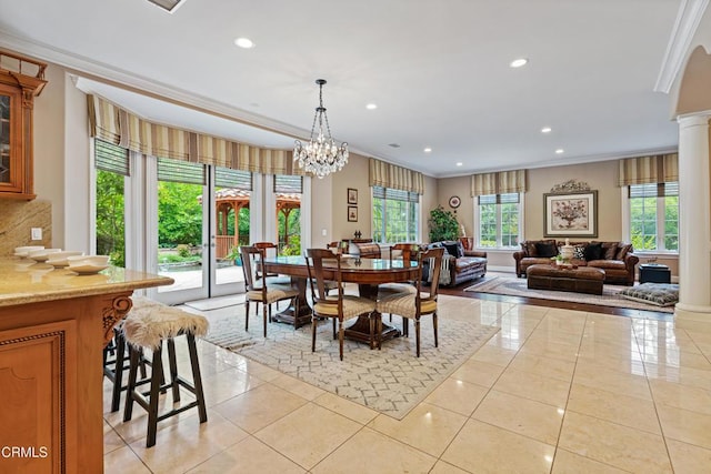 dining room with ornamental molding, decorative columns, a healthy amount of sunlight, and light tile patterned flooring