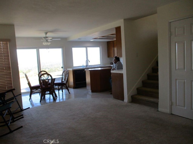 carpeted dining area with ceiling fan and sink