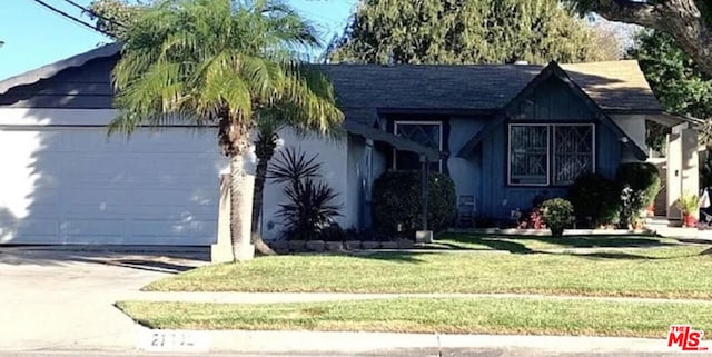 view of front of house with a garage and a front lawn