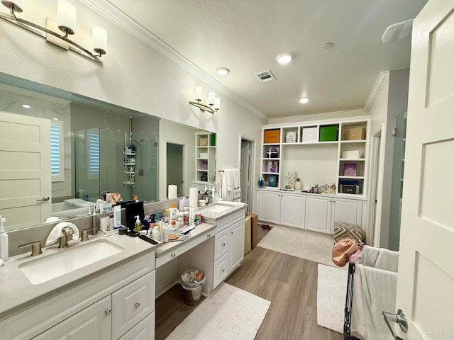 bathroom featuring vanity, hardwood / wood-style floors, a shower with shower door, and ornamental molding