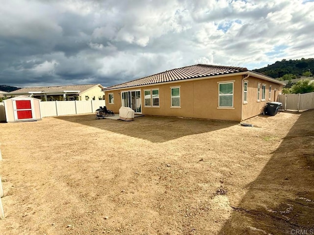 rear view of house featuring a patio area and a shed