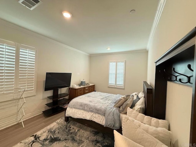 bedroom featuring ornamental molding and light hardwood / wood-style floors