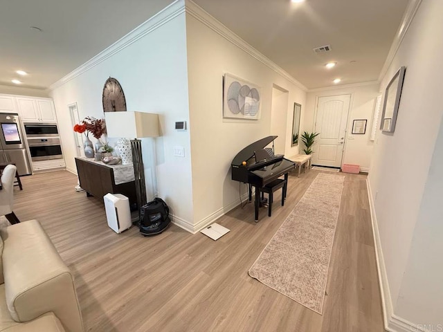 hall with ornamental molding and light wood-type flooring