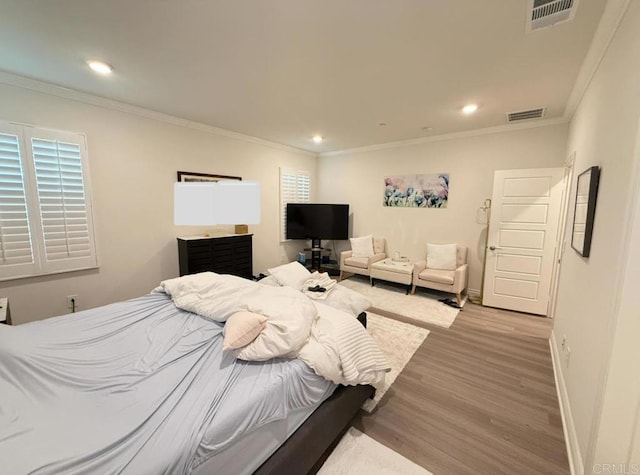 bedroom with crown molding and light hardwood / wood-style flooring