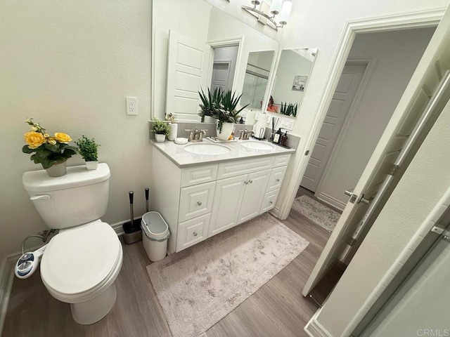 bathroom with toilet, hardwood / wood-style flooring, and vanity