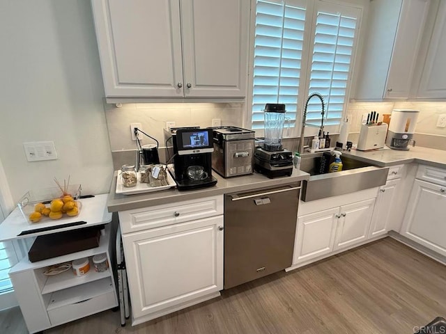 kitchen with sink, dishwasher, light hardwood / wood-style floors, white cabinets, and decorative backsplash