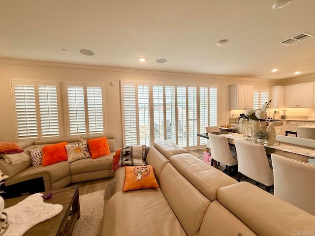 living room with crown molding, a healthy amount of sunlight, and hardwood / wood-style flooring