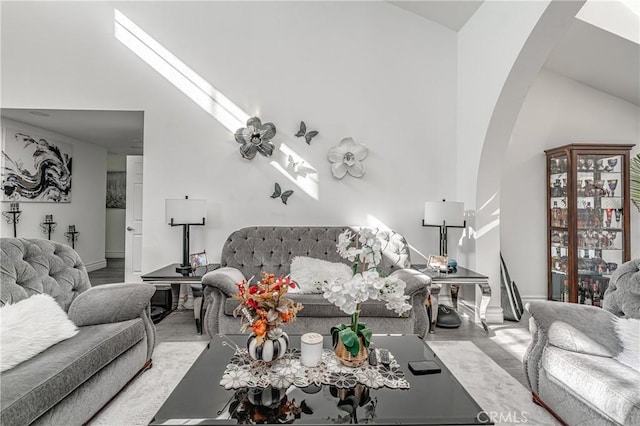 living room with light hardwood / wood-style flooring and high vaulted ceiling