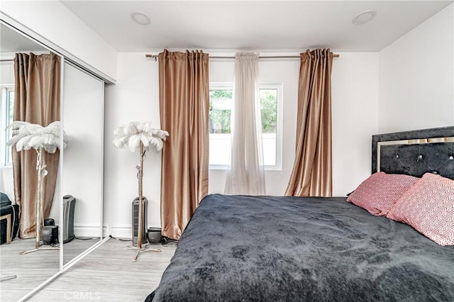 bedroom with light hardwood / wood-style flooring and a closet