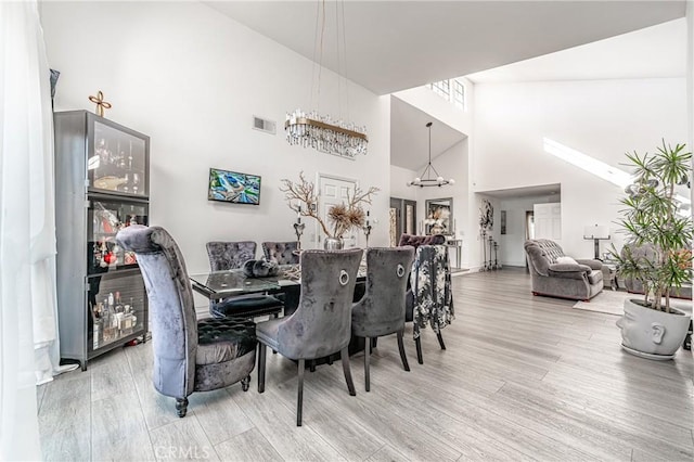 dining room featuring hardwood / wood-style flooring and high vaulted ceiling