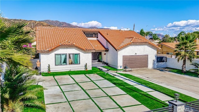 mediterranean / spanish-style house with a mountain view and a garage