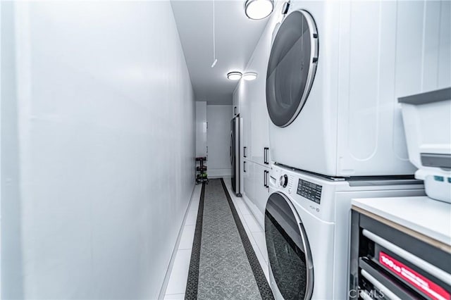 laundry room with tile patterned floors and stacked washing maching and dryer