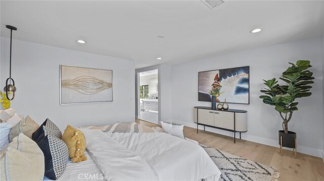 bedroom featuring ensuite bath and light hardwood / wood-style flooring