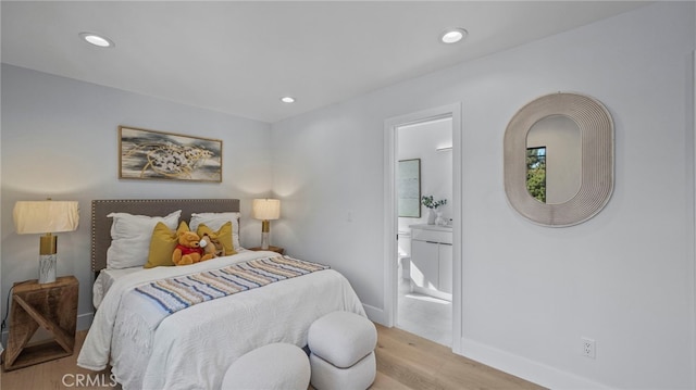 bedroom featuring connected bathroom and light hardwood / wood-style flooring