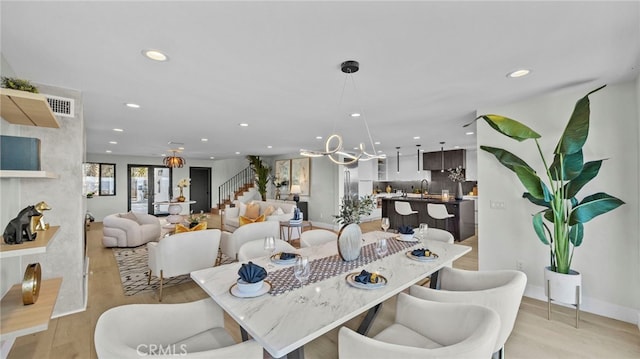 dining room with sink, light hardwood / wood-style floors, and an inviting chandelier