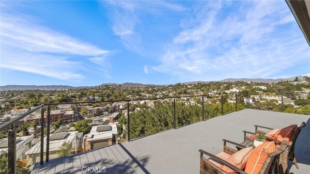 view of patio featuring a mountain view and a balcony