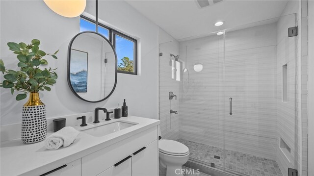 bathroom with vanity, toilet, and an enclosed shower