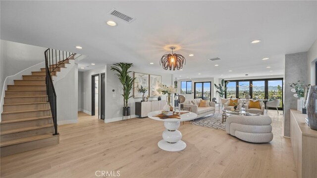 living room with an inviting chandelier and light wood-type flooring