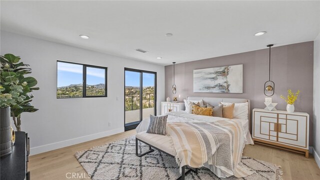 bedroom with access to exterior and light hardwood / wood-style flooring