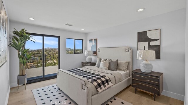 bedroom with access to outside and light hardwood / wood-style floors