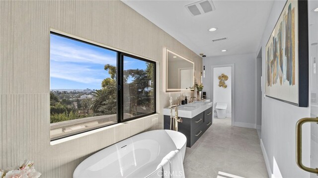 bathroom featuring a bathtub, vanity, concrete floors, and toilet