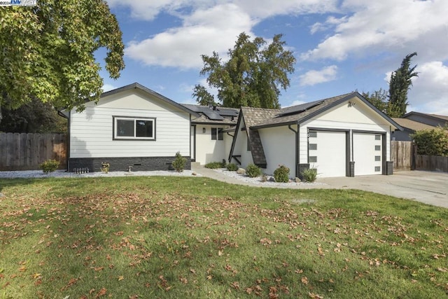 ranch-style home with solar panels, a garage, and a front lawn