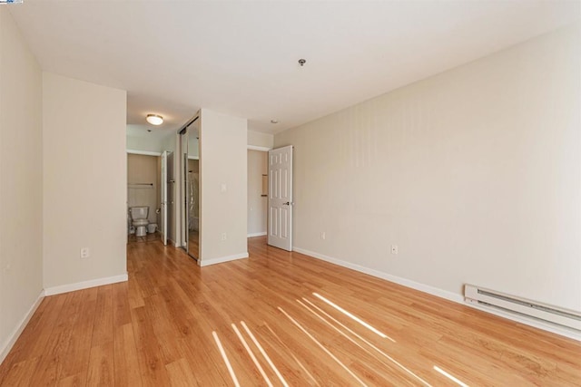 spare room featuring light hardwood / wood-style floors and a baseboard radiator