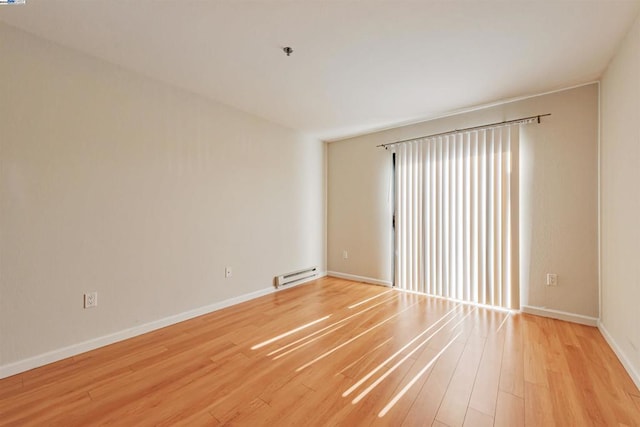 spare room with light wood-type flooring and baseboard heating