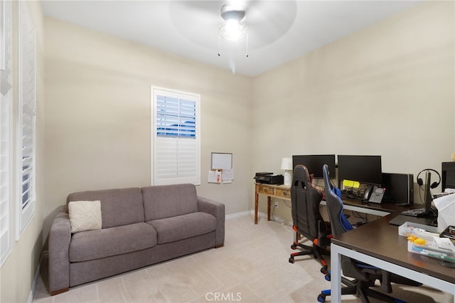 office space featuring light carpet and ceiling fan