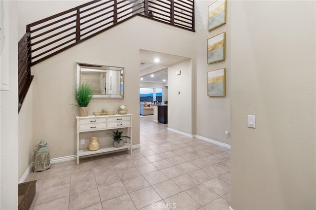 foyer entrance with light tile patterned flooring and a high ceiling