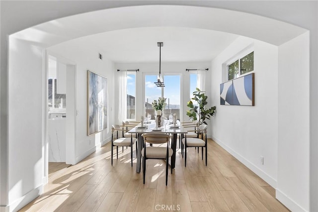 dining space with a chandelier and light hardwood / wood-style flooring