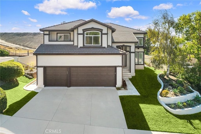 view of front of home with a mountain view, a front yard, and a garage