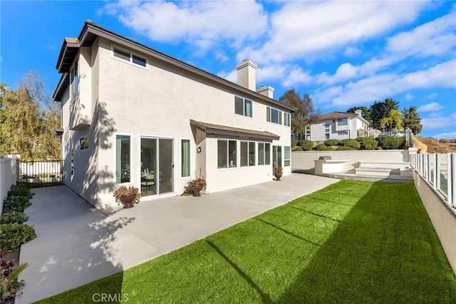 rear view of property featuring a lawn and a patio