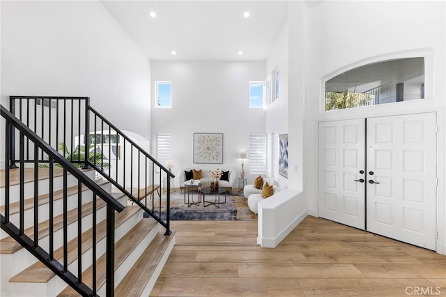 entryway with a high ceiling and light hardwood / wood-style flooring