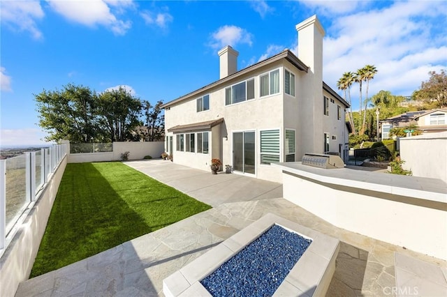 rear view of house featuring a patio and a lawn