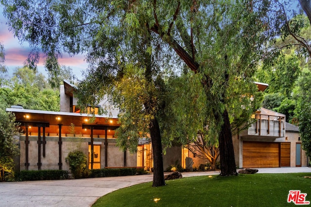 modern home featuring a garage and a yard