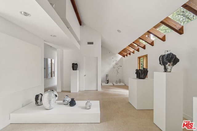 interior space featuring beam ceiling and high vaulted ceiling