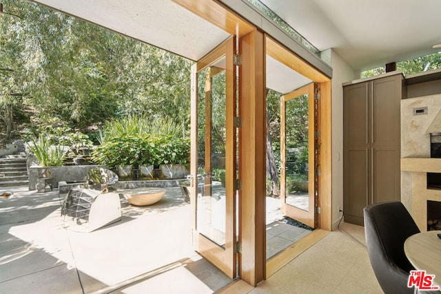 doorway to outside with plenty of natural light and a fireplace