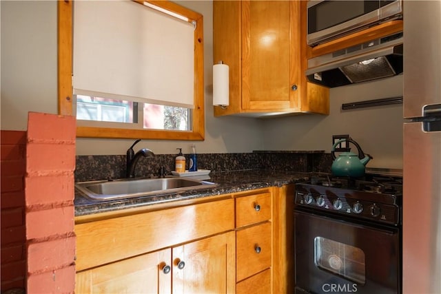 kitchen with black range with gas stovetop, ventilation hood, sink, dark stone countertops, and stainless steel microwave