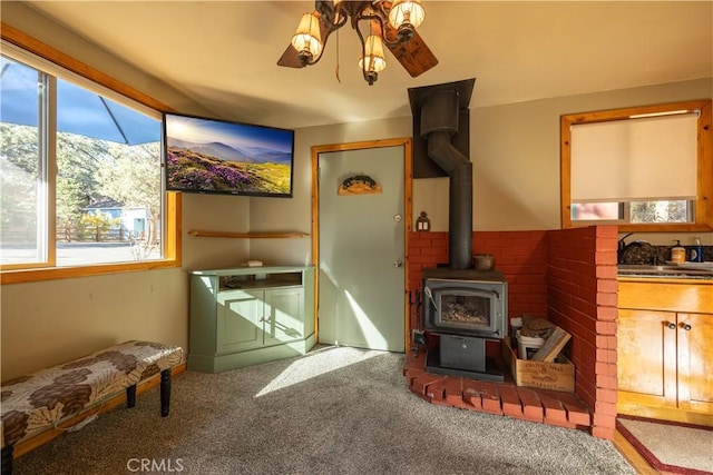 interior space with a wood stove, ceiling fan, and sink